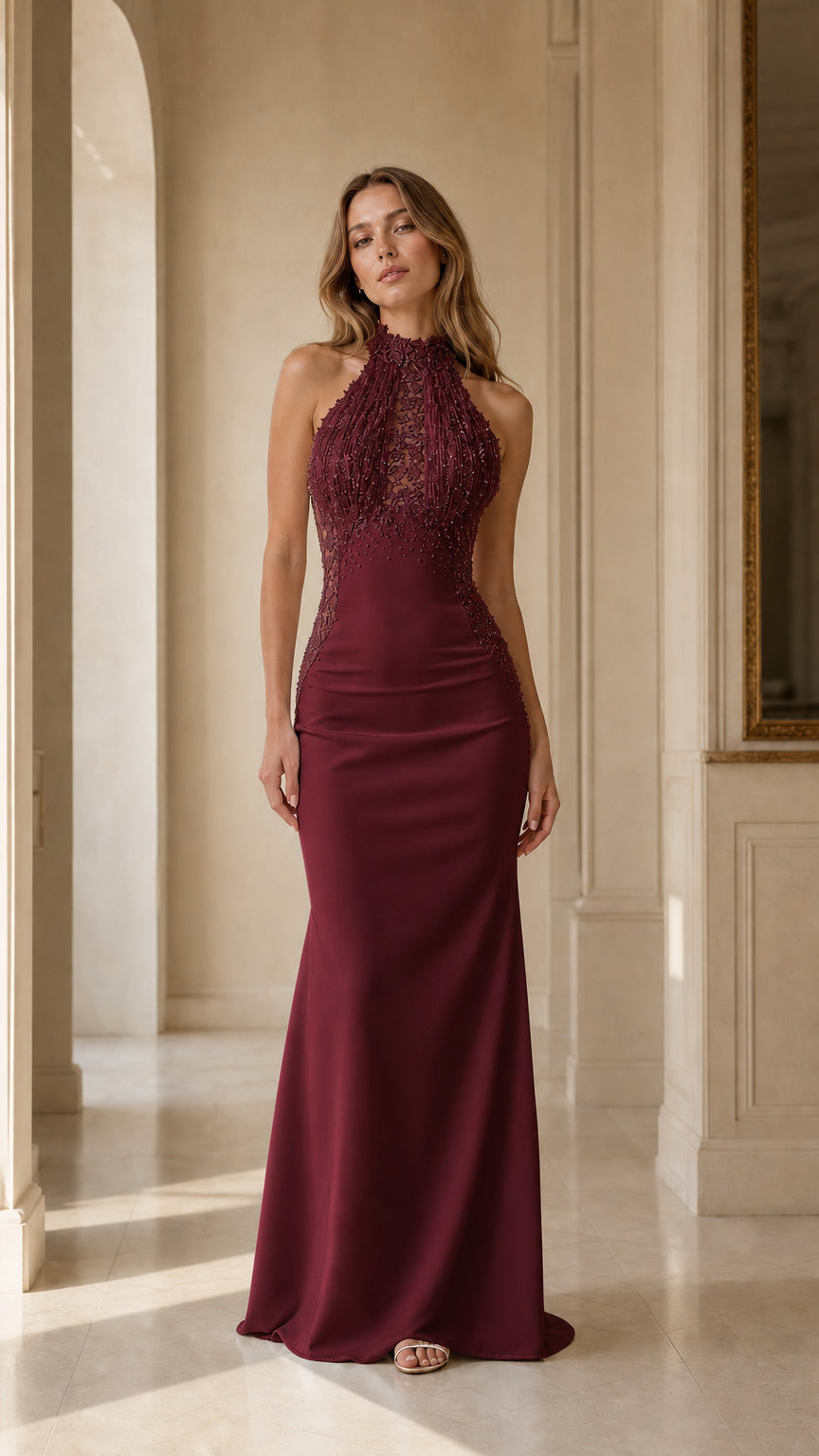 Front view of woman wearing burgundy halter beaded fringe mermaid evening gown