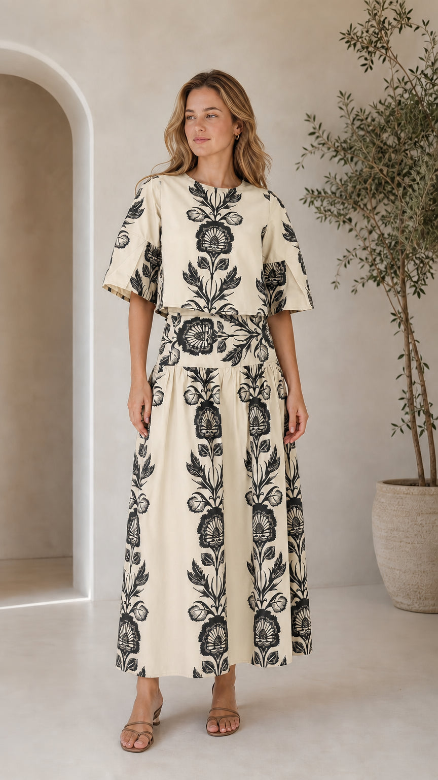 Woman wearing cream floral print crop top and tiered maxi skirt set
