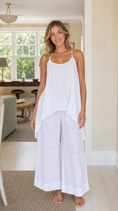 Front view of woman wearing white handkerchief cami top and wide-leg pants set
