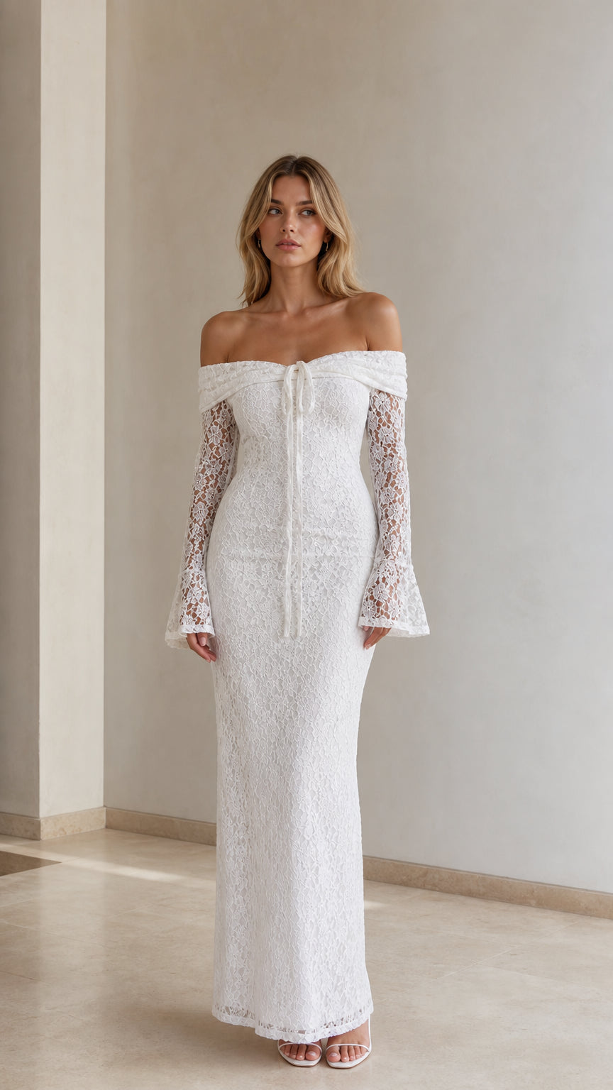 Front view of woman wearing white off-the-shoulder lace maxi dress with long bell sleeves