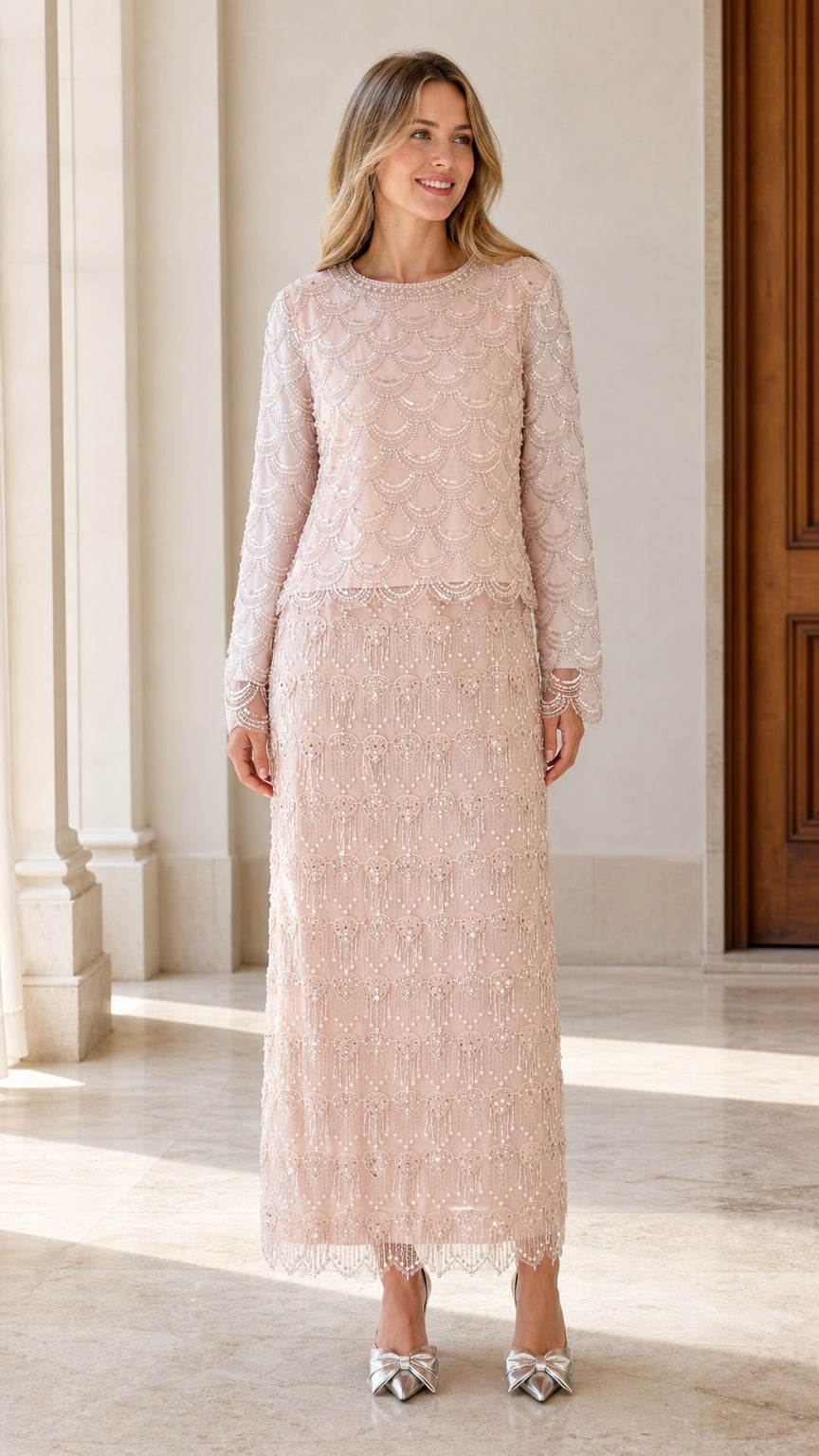 Front view of woman wearing blush pink scalloped beaded long sleeve maxi evening dress
