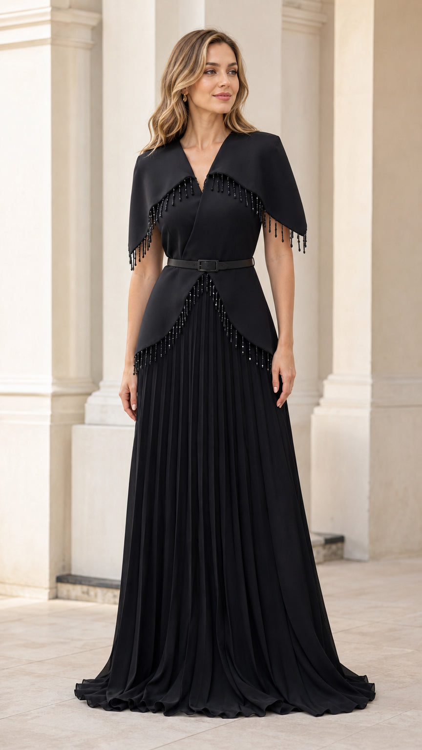 Full-length front view of woman wearing elegant black beaded capelet pleated evening gown