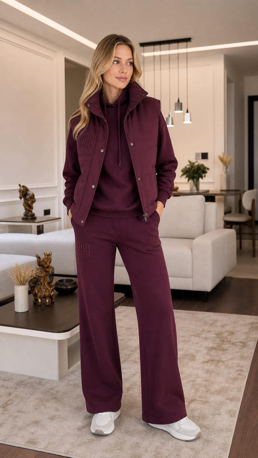 Front view of model wearing burgundy 3-piece tracksuit set with padded vest, hoodie, and wide-leg pants