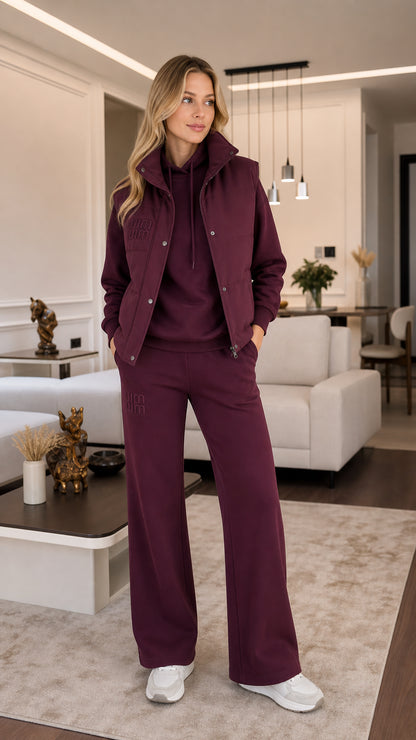 Front view of model wearing burgundy 3-piece tracksuit set with padded vest, hoodie, and wide-leg pants