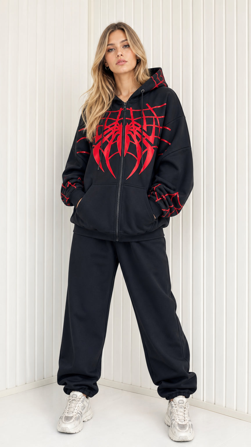 Full front view of model wearing black graphic spider web zip hoodie and sweatpants set