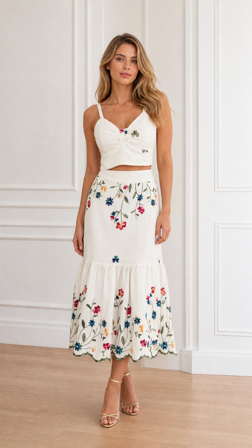 Front view of model wearing white floral embroidered crop top and tiered midi skirt set