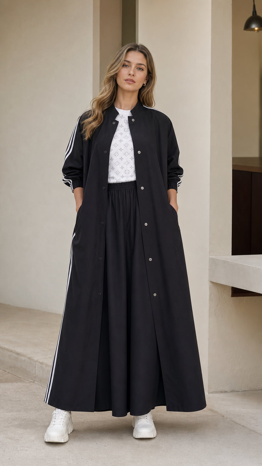 Front full view of woman wearing black sporty maxi duster and wide leg pants set with white sneakers