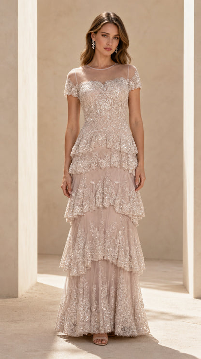 Front view of champagne sequined tiered maxi gown with illusion neckline