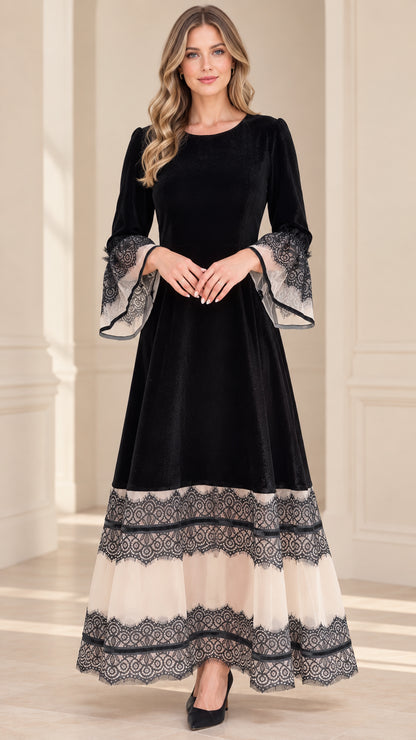 Front view of model wearing black velvet maxi dress with tiered lace hem and bell sleeves