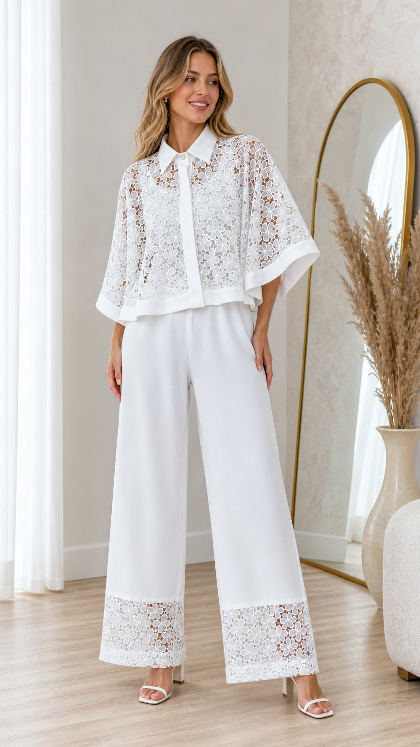 Front view of model wearing white floral lace cape top and matching wide leg pants
