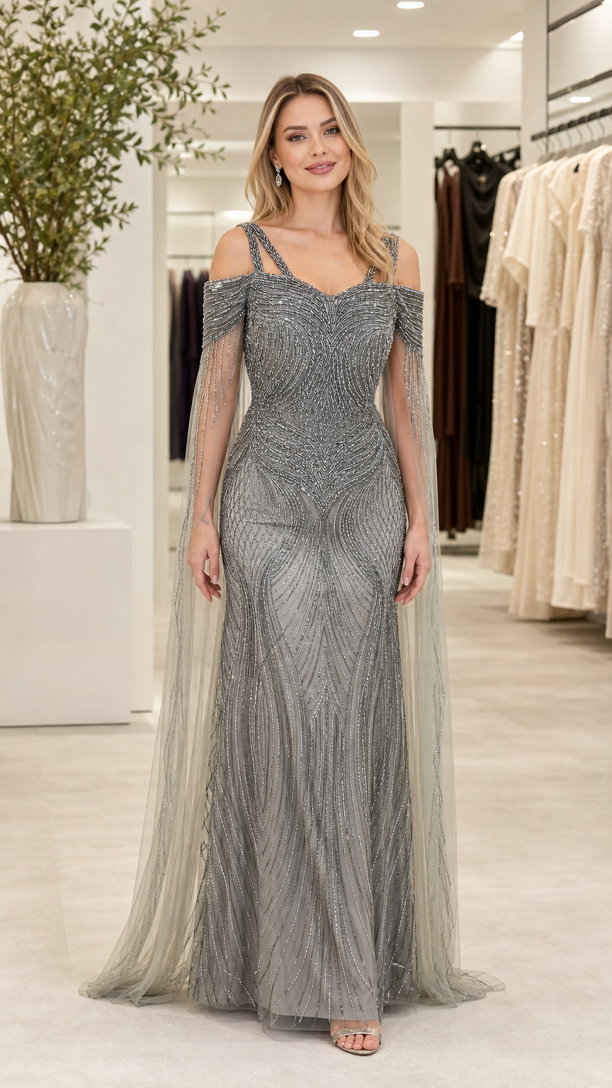 Front view of woman wearing silver cold shoulder beaded evening gown with sheer cape sleeves
