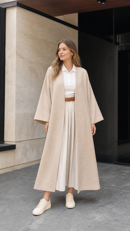 Full front view of woman wearing beige embossed jacquard maxi kimono duster over a white shirt and pleated skirt