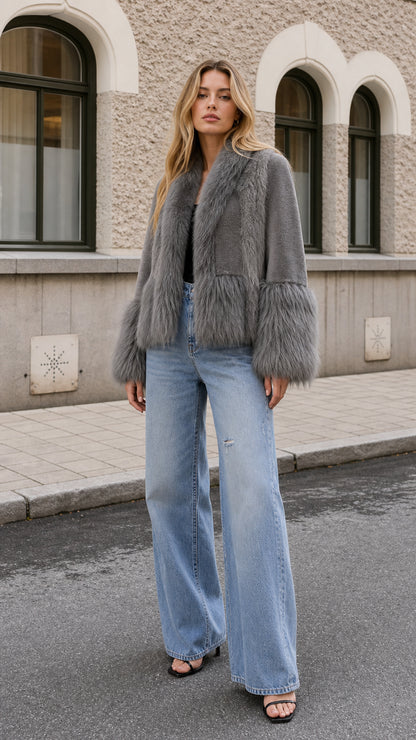 Model wearing grey plush faux fur jacket with wide-leg light wash jeans, front view