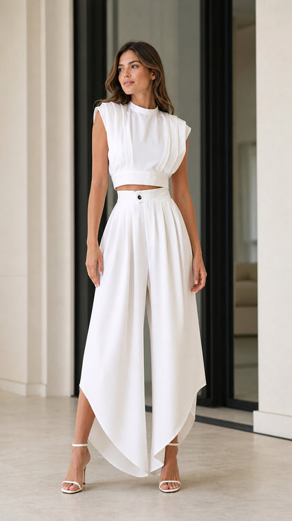 Model wearing white pleated sleeveless mock neck crop top and split wide-leg palazzo pants two-piece set front view