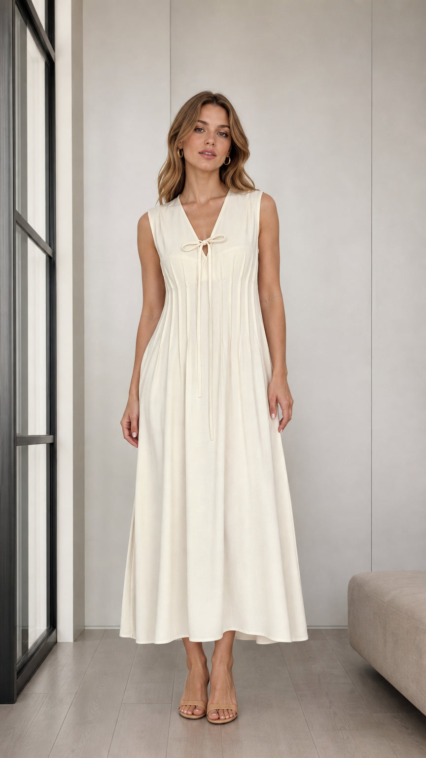 Front full view of woman wearing Cream sleeveless pleated midi dress with tie V-neck