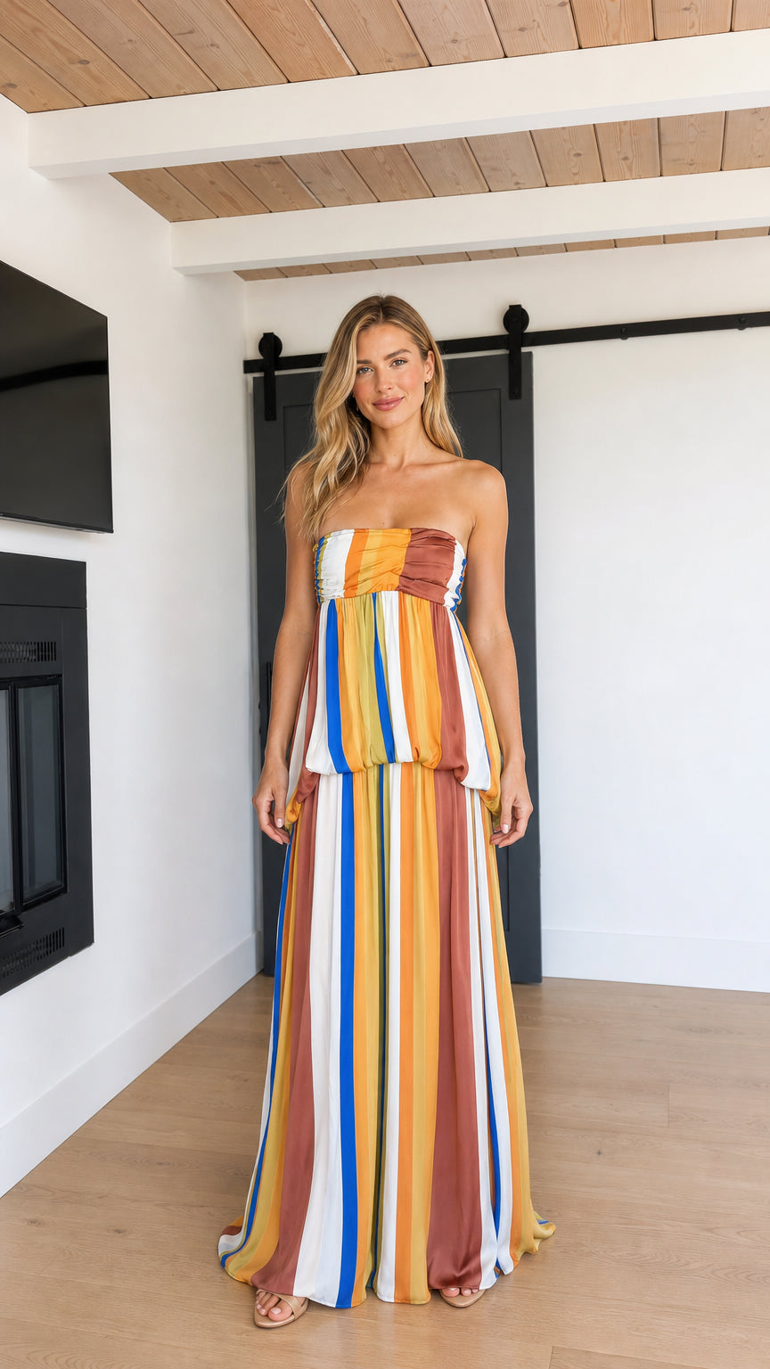 Front view of model wearing Mustard Multi strapless striped tiered maxi dress
