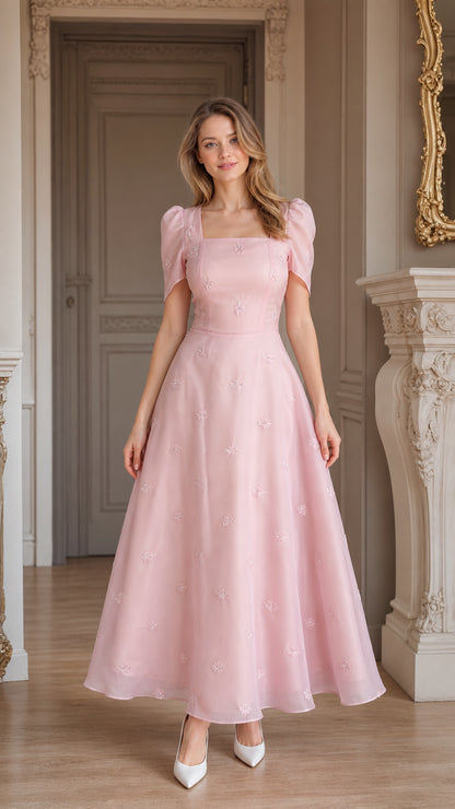 Front view of woman wearing blush pink embroidered square neck midi dress with puff sleeves