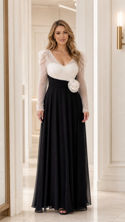 Front view of woman wearing two-tone white sequin bodice and black chiffon skirt evening gown with 3D waist flower