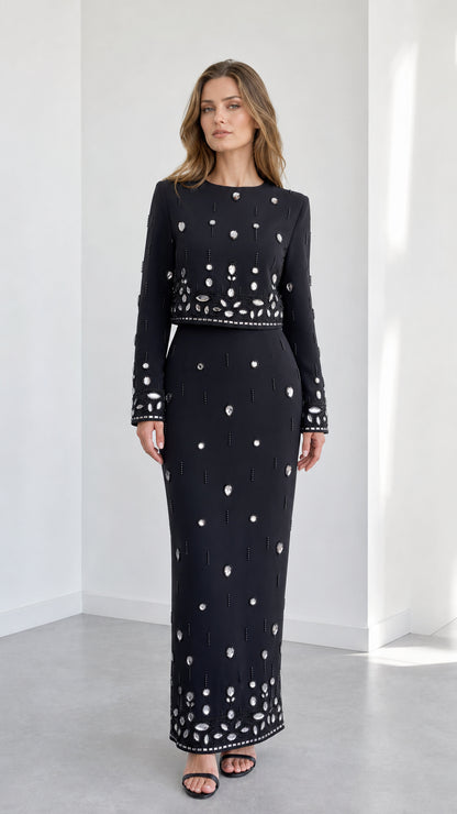 Front view of black long sleeve embellished crop top and column maxi skirt two-piece set