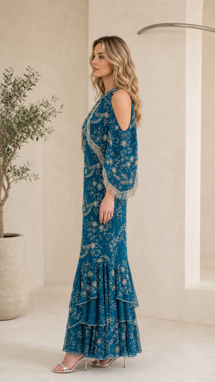 Side profile of model in Teal Blue beaded fringe capelet gown showing silhouette
