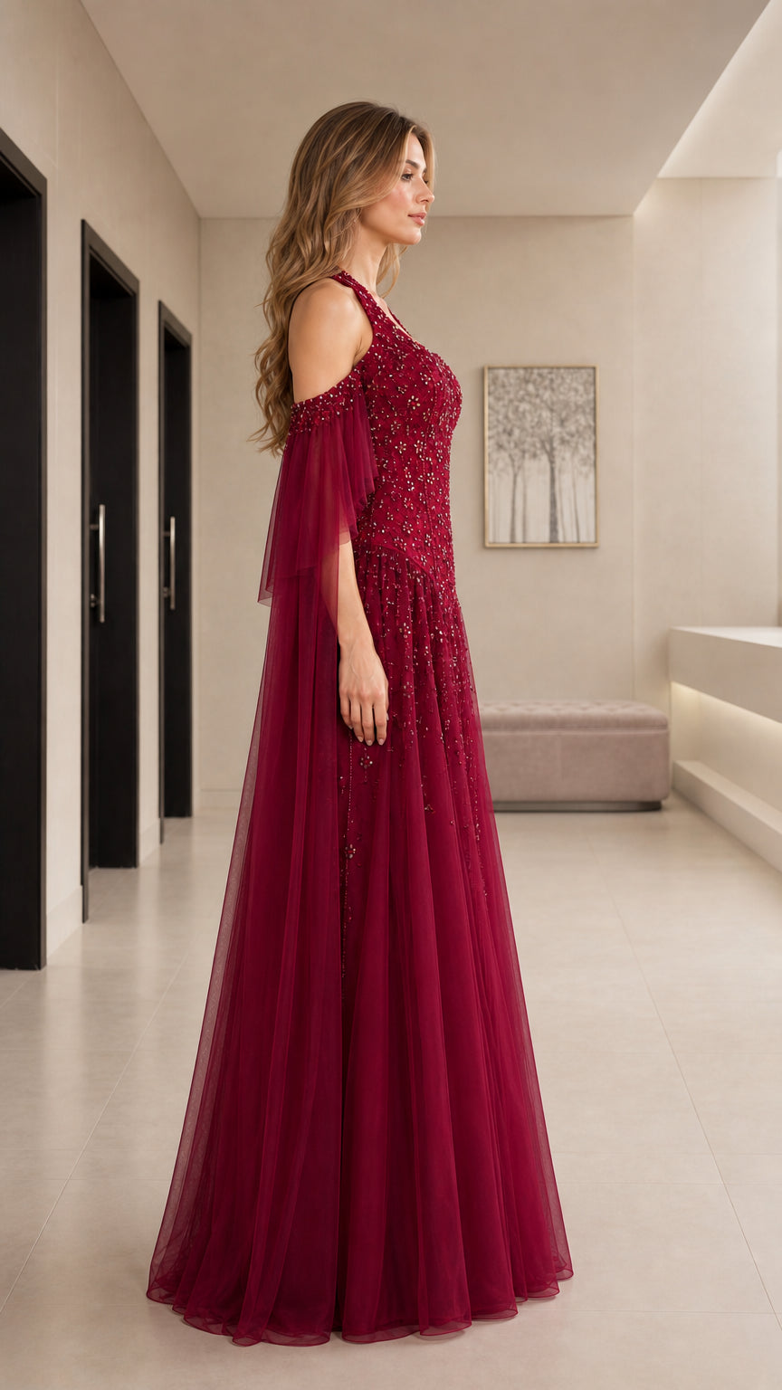 Side view of burgundy cold-shoulder embellished formal gown with tulle skirt