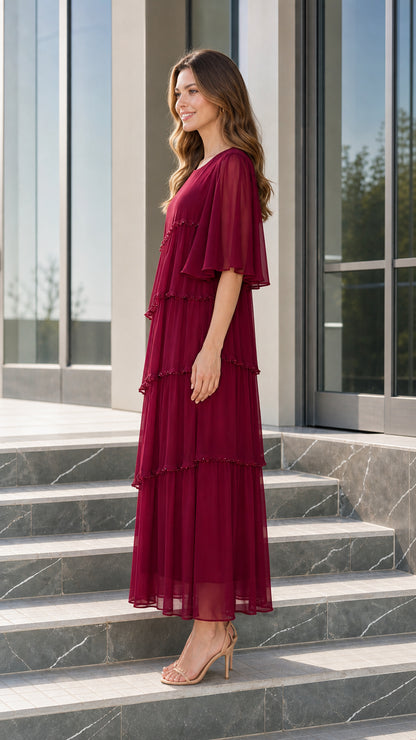 Side profile view of woman modeling burgundy tiered evening maxi dress