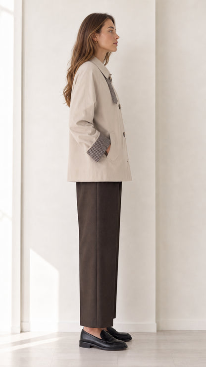 Side profile of women's beige short button-front jacket with plaid cuff accent