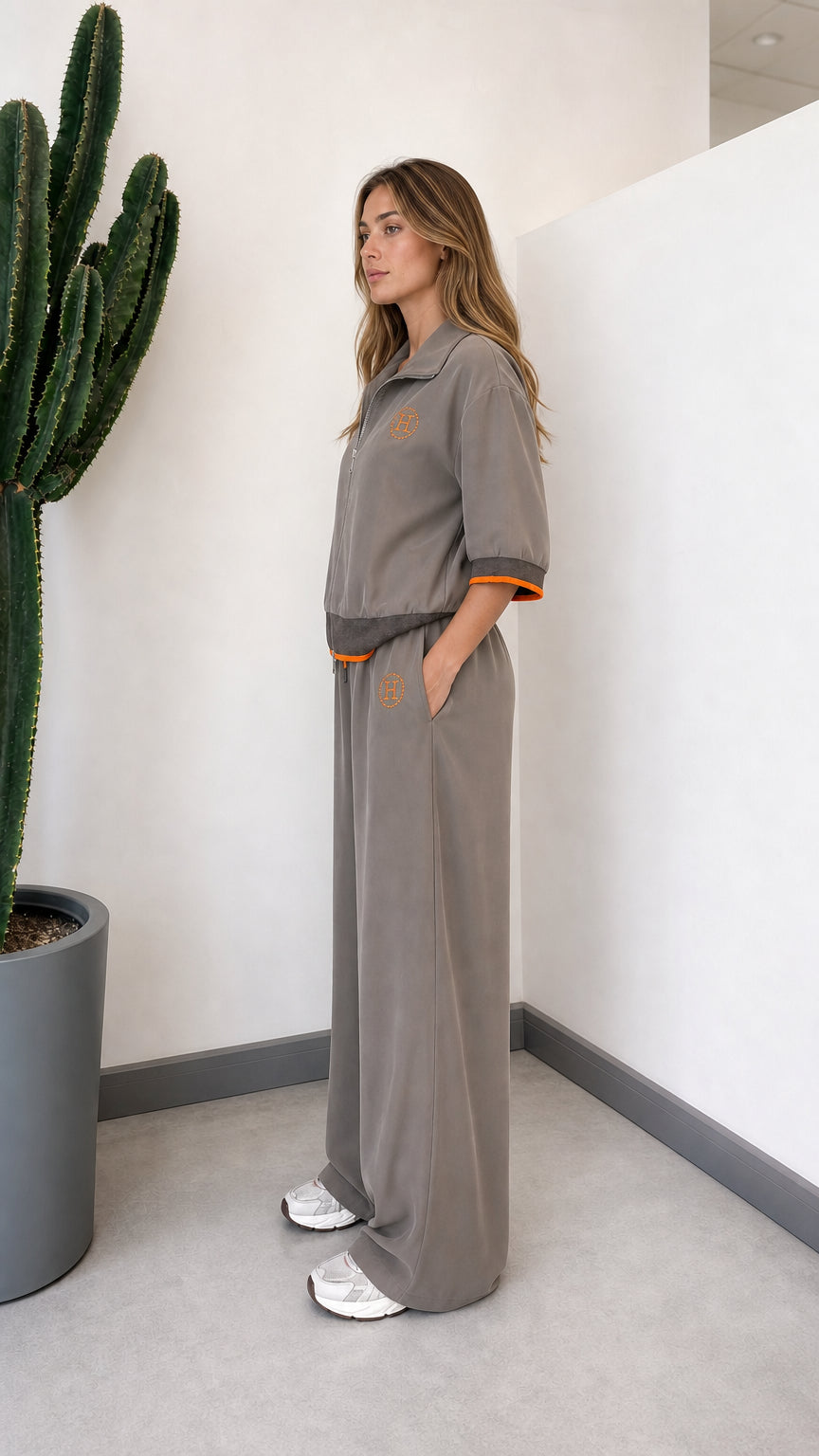 Side view of model wearing grey short-sleeve zip-up tracksuit set