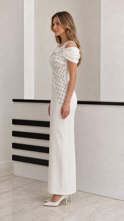 Side profile view of model wearing white off-the-shoulder embellished formal evening dress