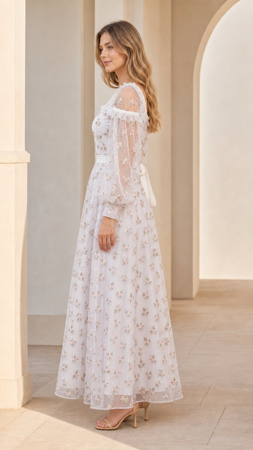 Side angle view of model in white floral embroidered tulle gown