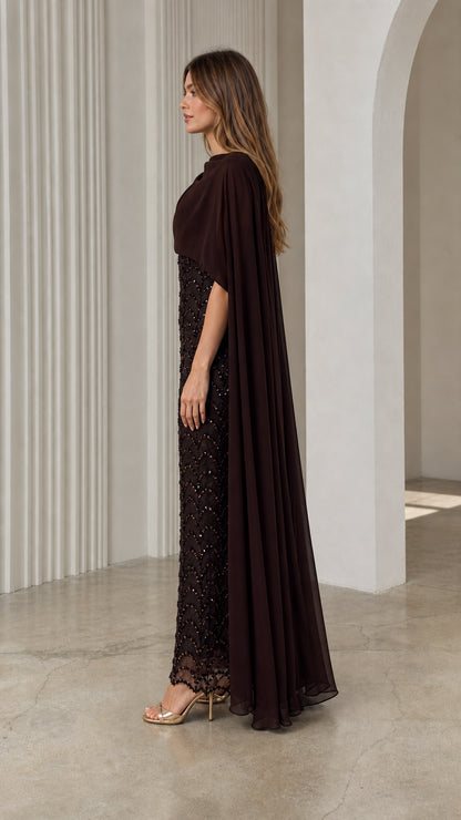 Side profile view of dark brown sequined evening gown showcasing sheer chiffon back cape drape