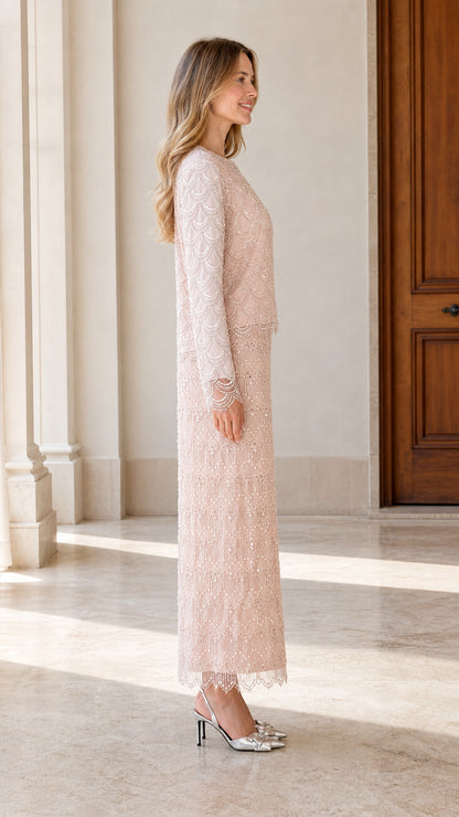 Side view of woman in blush pink long sleeve embellished evening gown
