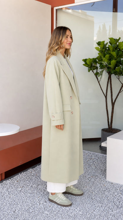 Side profile view of woman modeling Sage Green tailored maxi coat