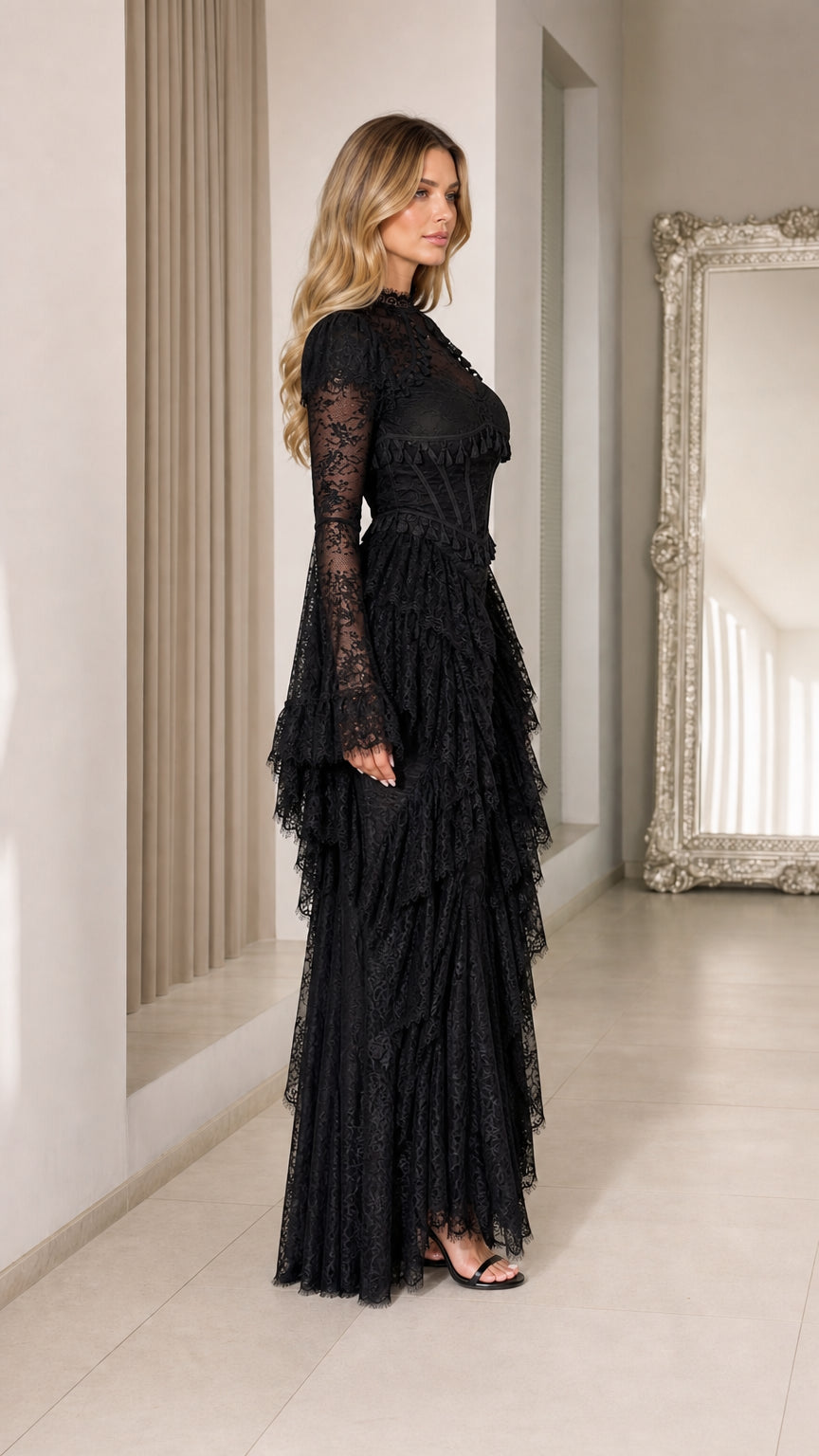 Side profile view of black lace long sleeve evening gown with tiered skirt