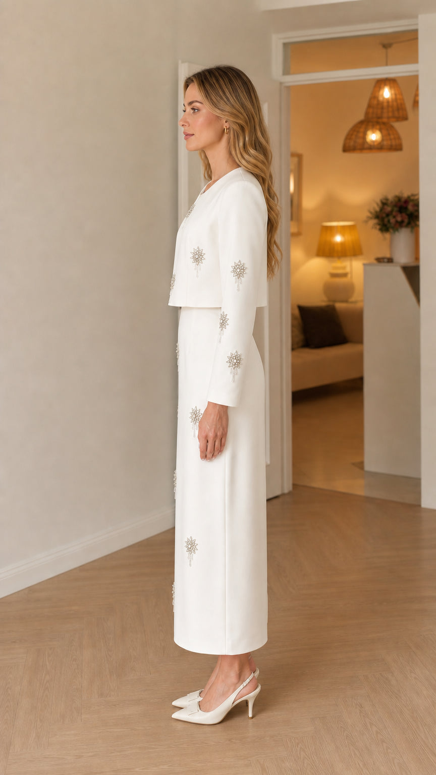 Side profile view of woman in white embellished maxi dress