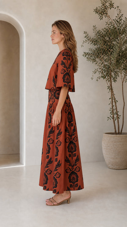 Side view of rust floral print two-piece crop top and maxi skirt set