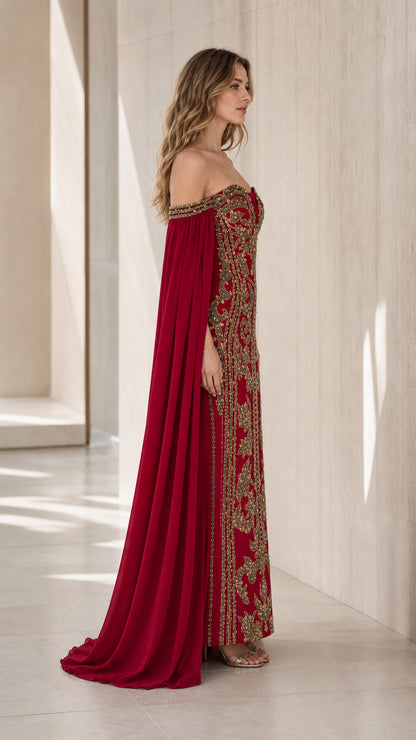 Side profile view of burgundy cape evening dress showing sweeping floor-length drape