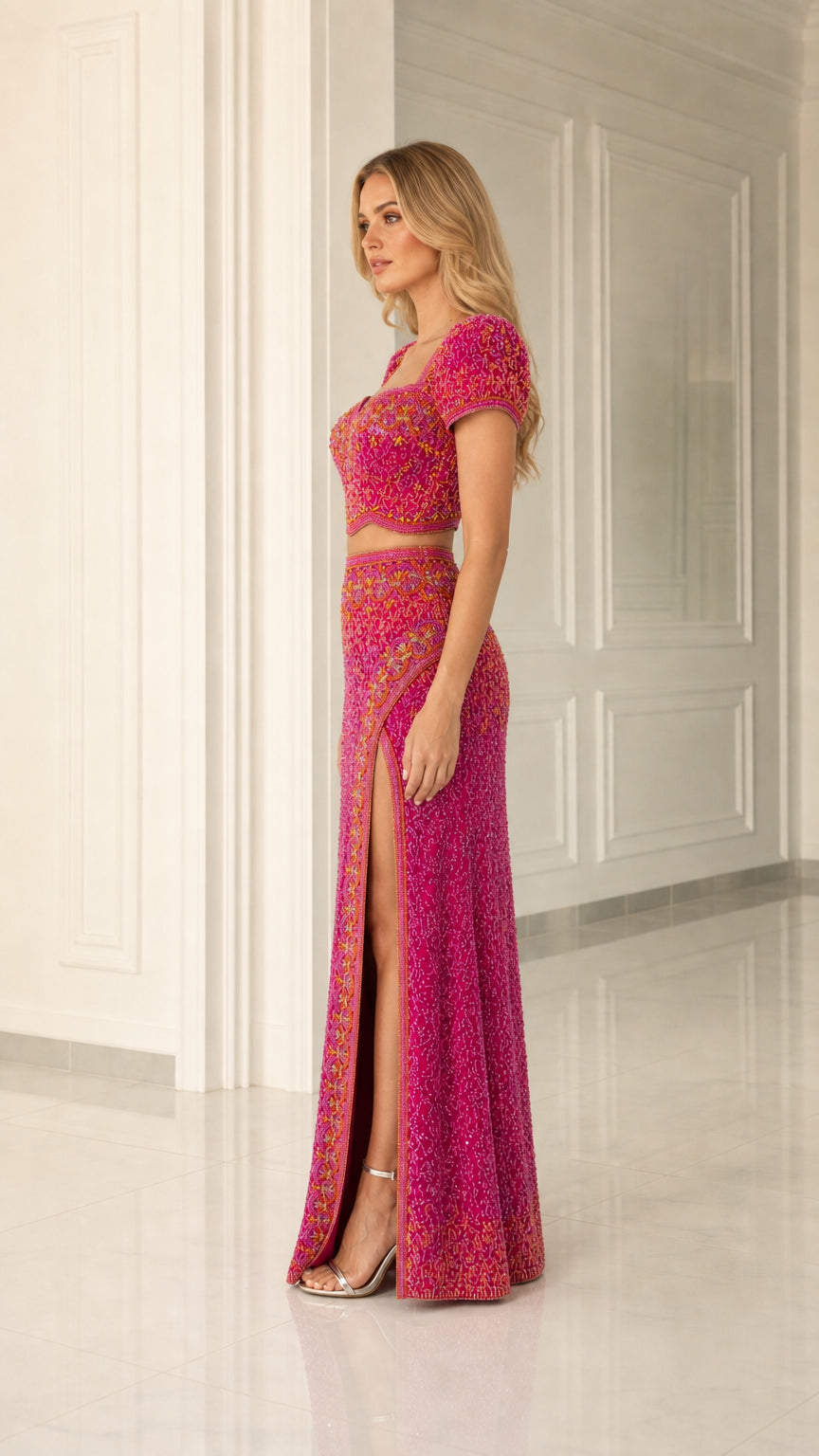 Side view of model in magenta beaded crop top and side slit maxi evening skirt