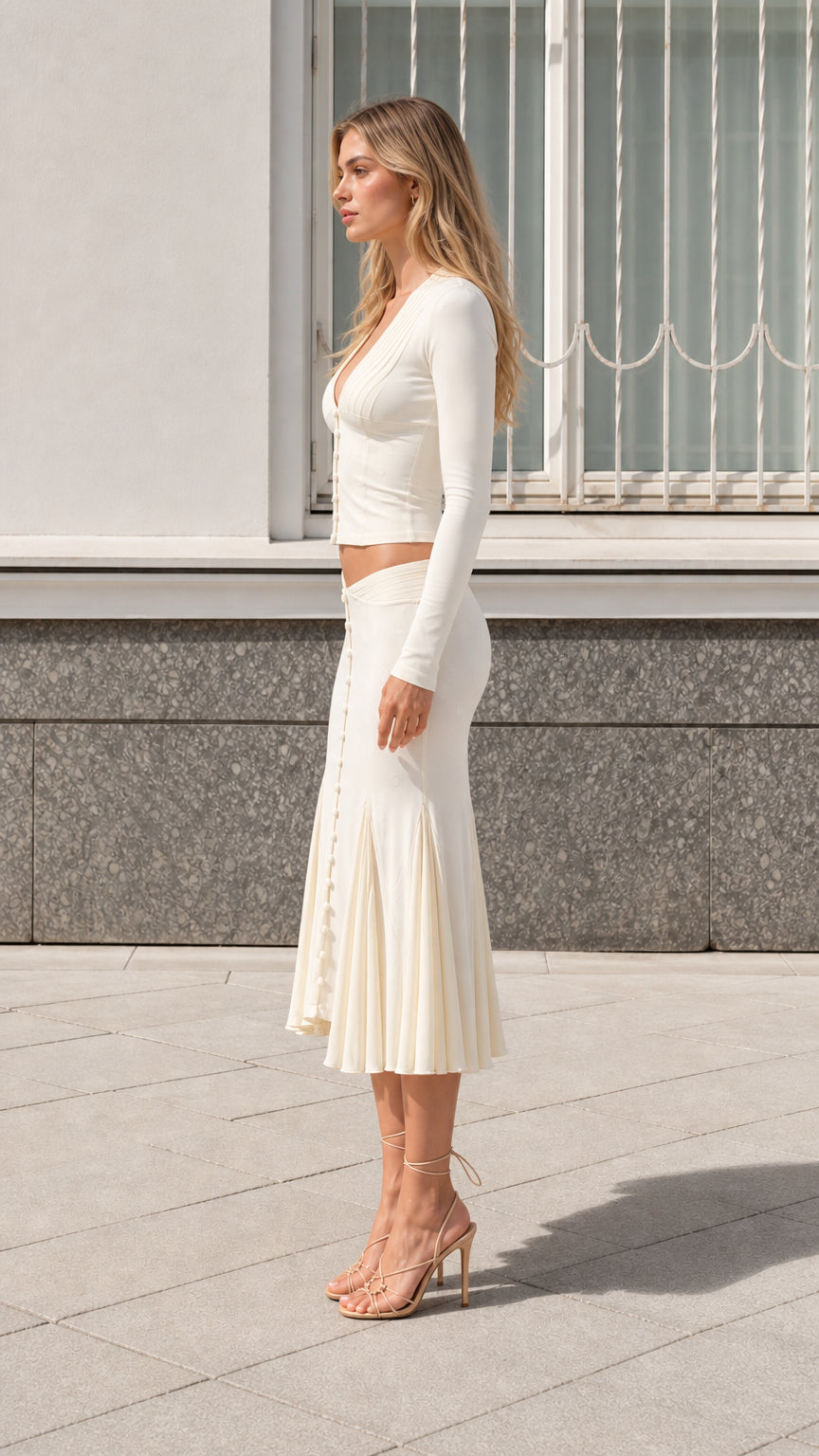 Side profile view of model wearing cream two-piece knit midi skirt set
