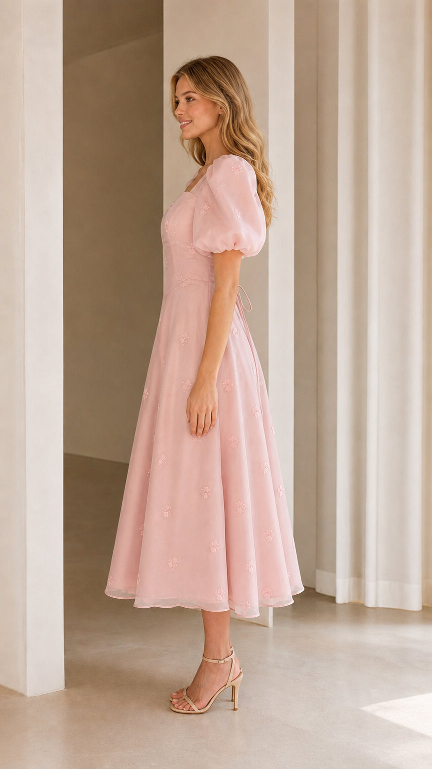 Side view of woman wearing blush pink puff sleeve A-line midi dress