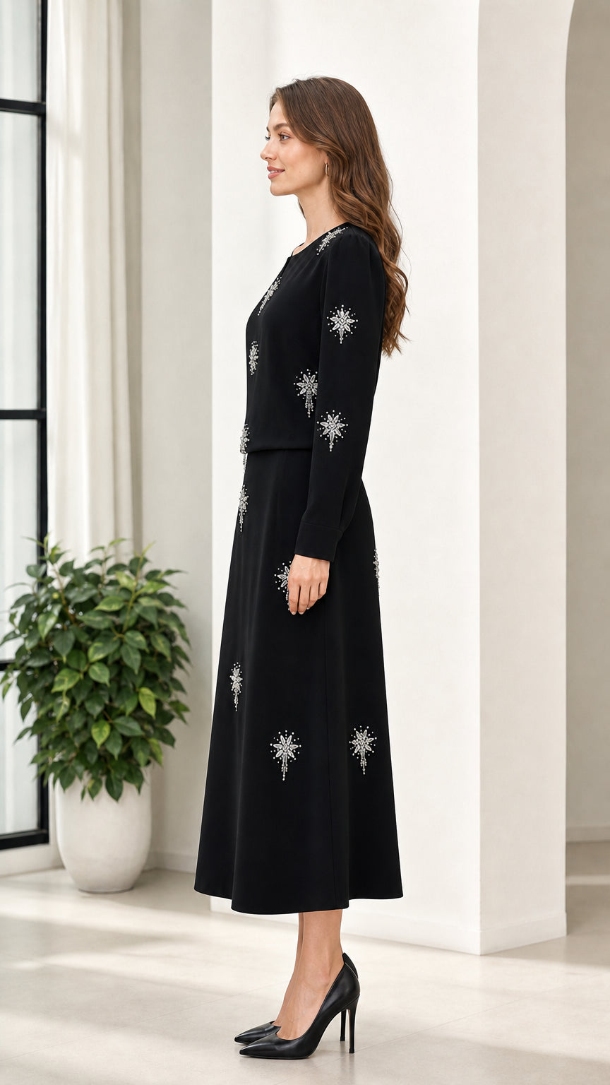 Side view of woman in black long sleeve rhinestone embellished midi dress