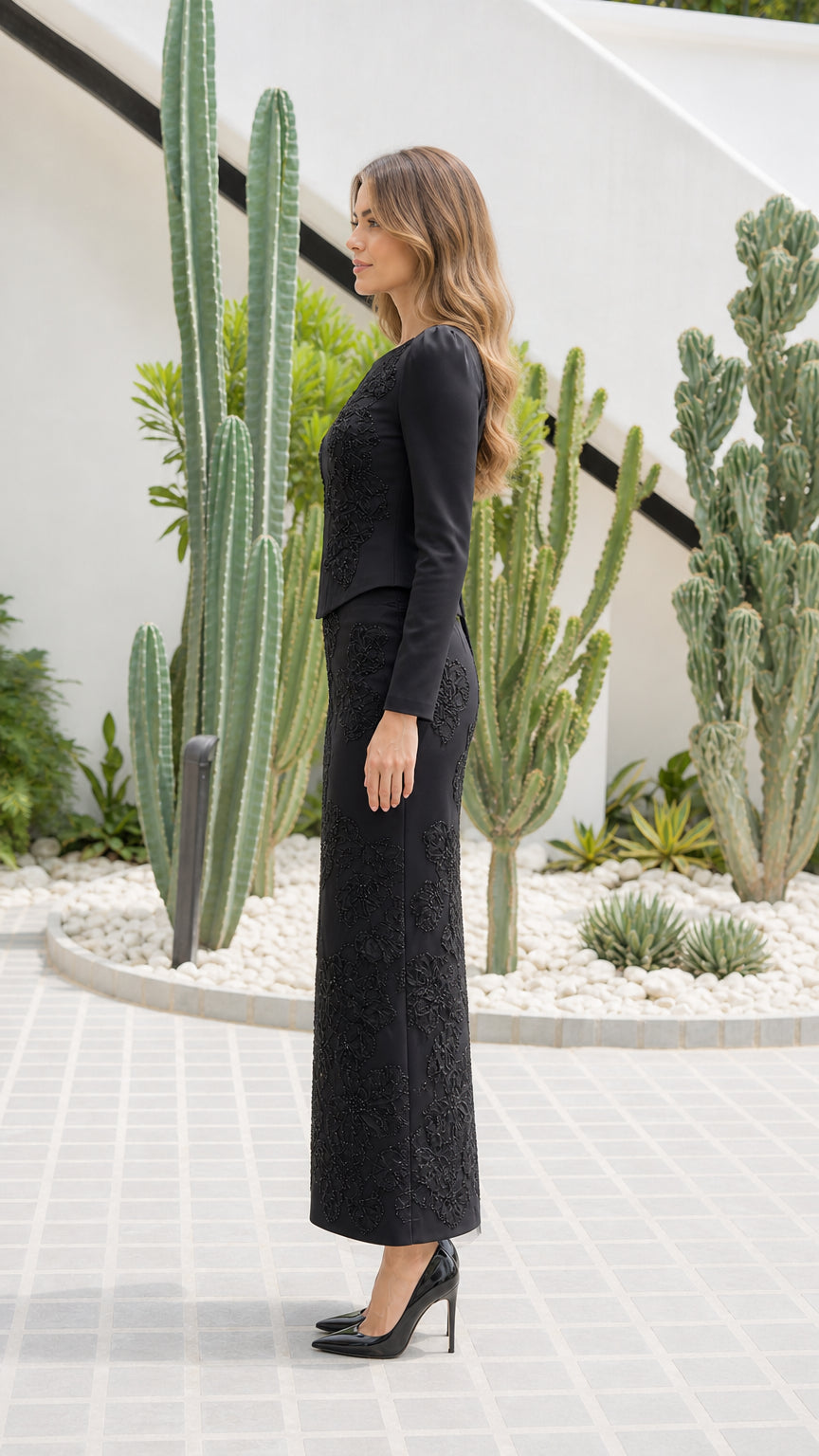 Side profile view of black long-sleeve evening top and matching maxi skirt