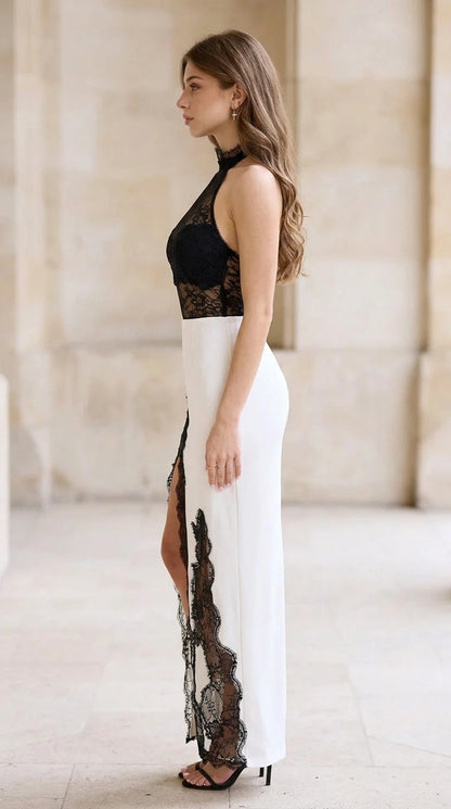 Side profile of white and black halter evening dress showing dramatic high leg slit