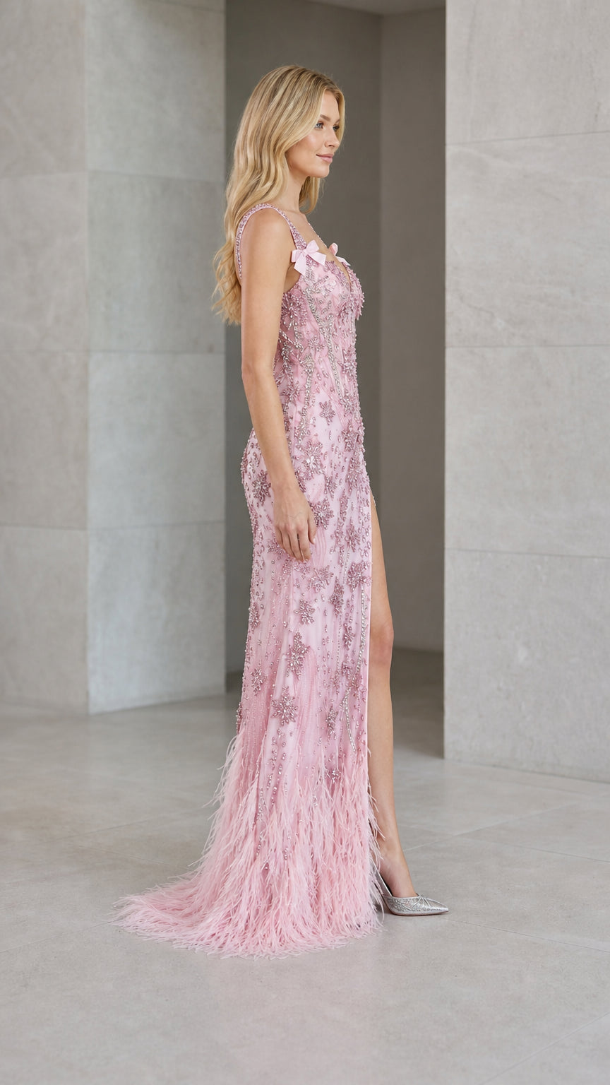 Side angle view of model wearing blush pink feather hem evening dress