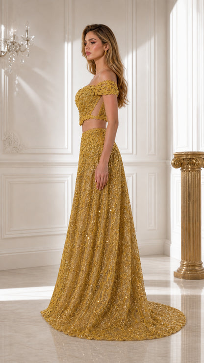 Side profile view of gold embroidered two-piece evening set showing train and crop top cut