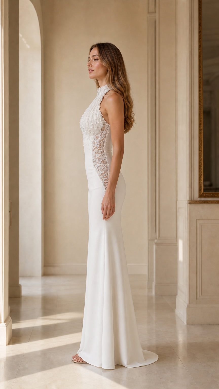 Side profile view of woman wearing white beaded halter formal maxi gown