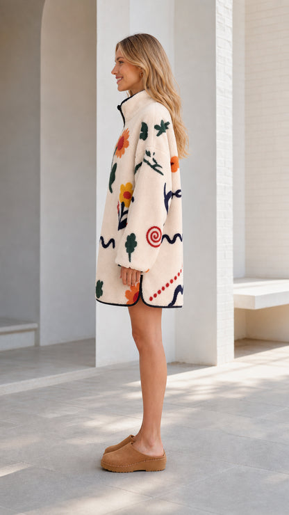 Side view of the cream printed fleece jacket showing its relaxed silhouette