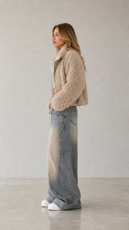 Side profile of woman wearing beige cropped sherpa fleece zip jacket