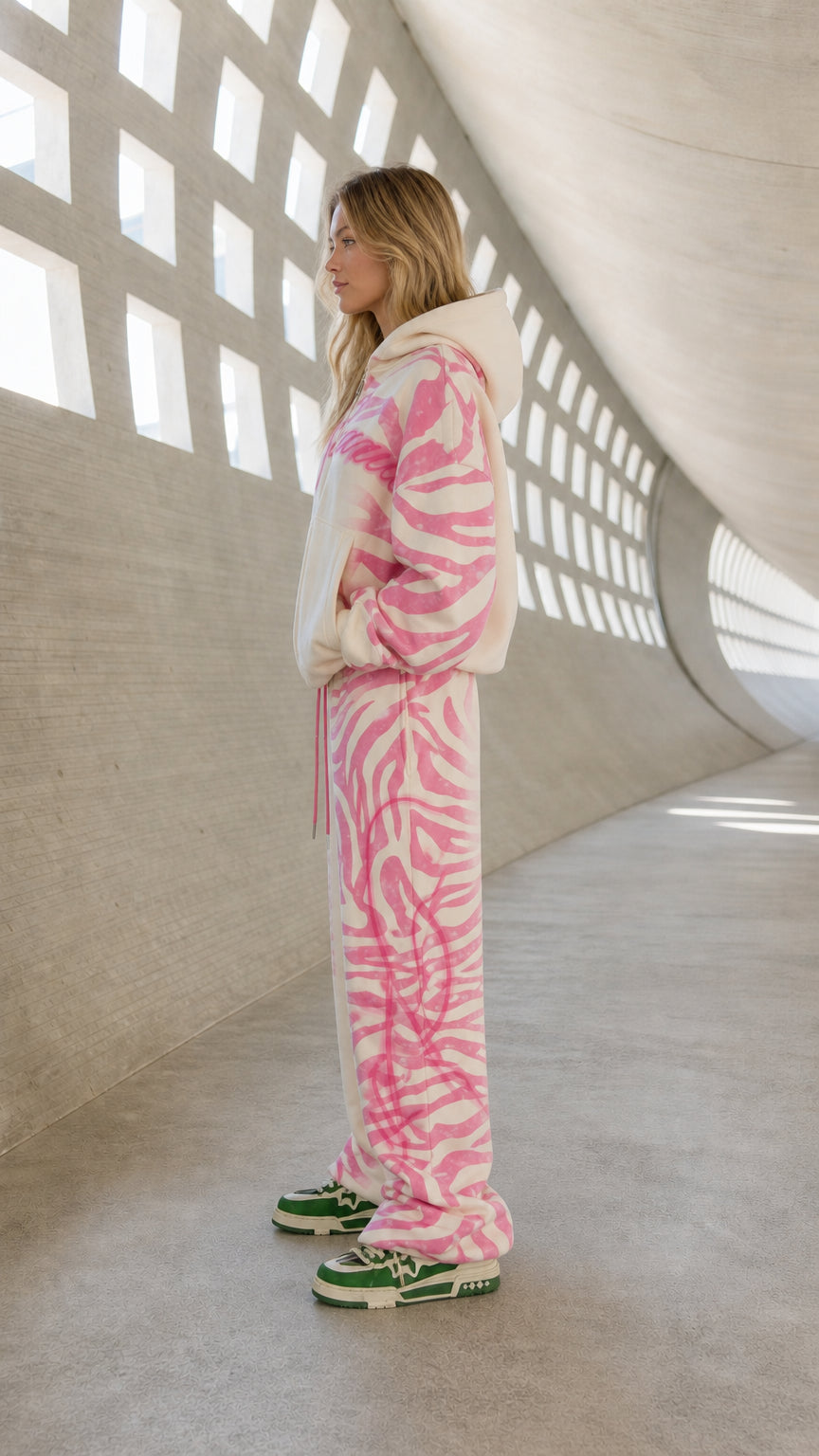 Side profile view of cream and pink 2-piece graphic tracksuit set