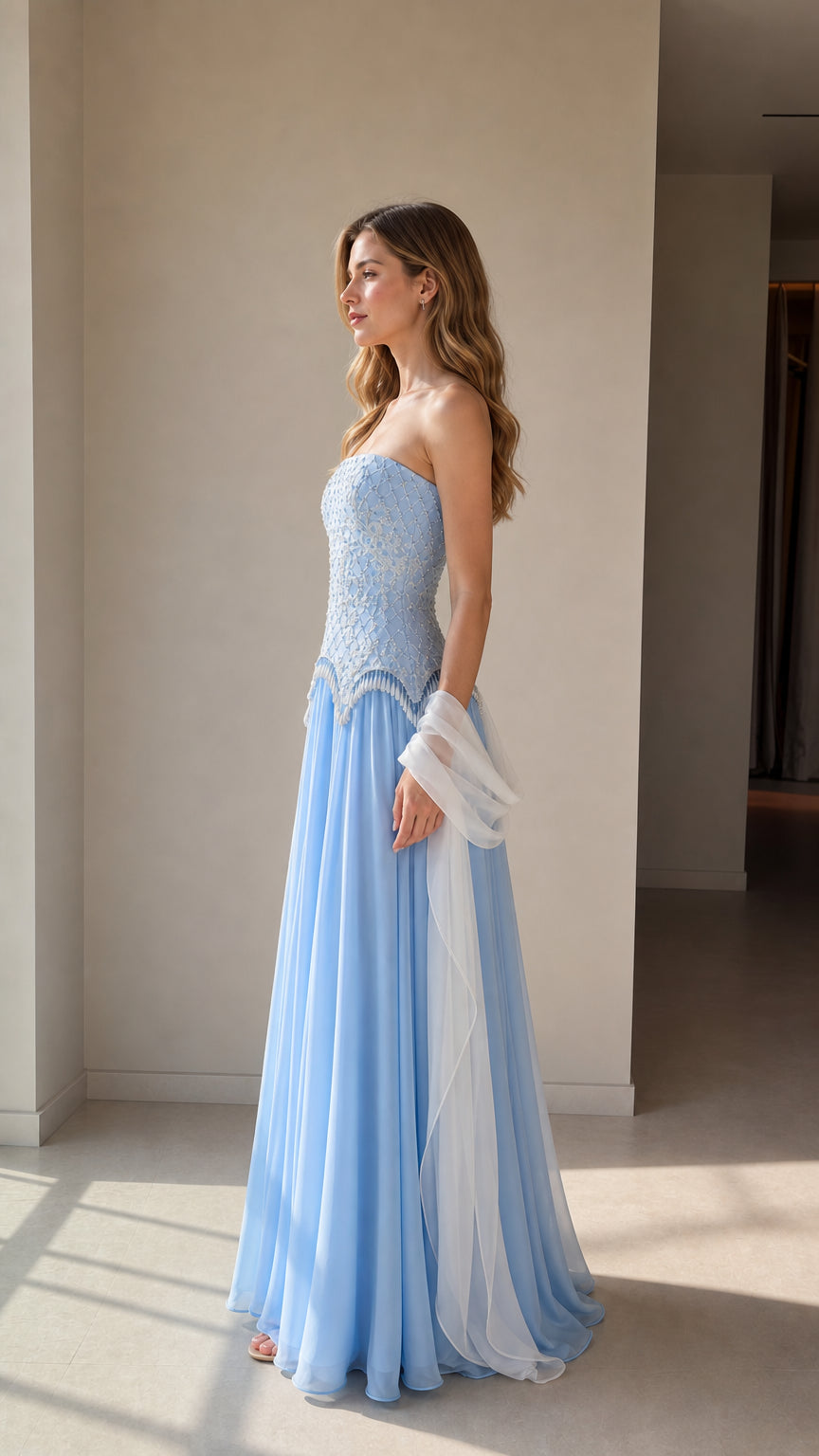 Side profile view of light blue beaded corset maxi dress with flowing skirt
